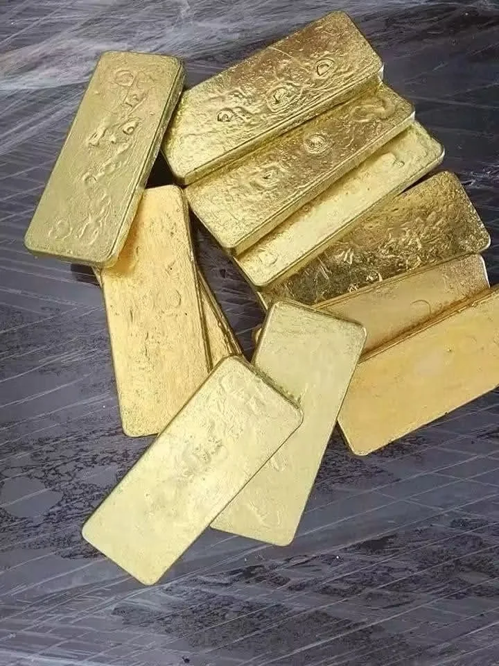 Loose rectangular gold bars on a dark surface